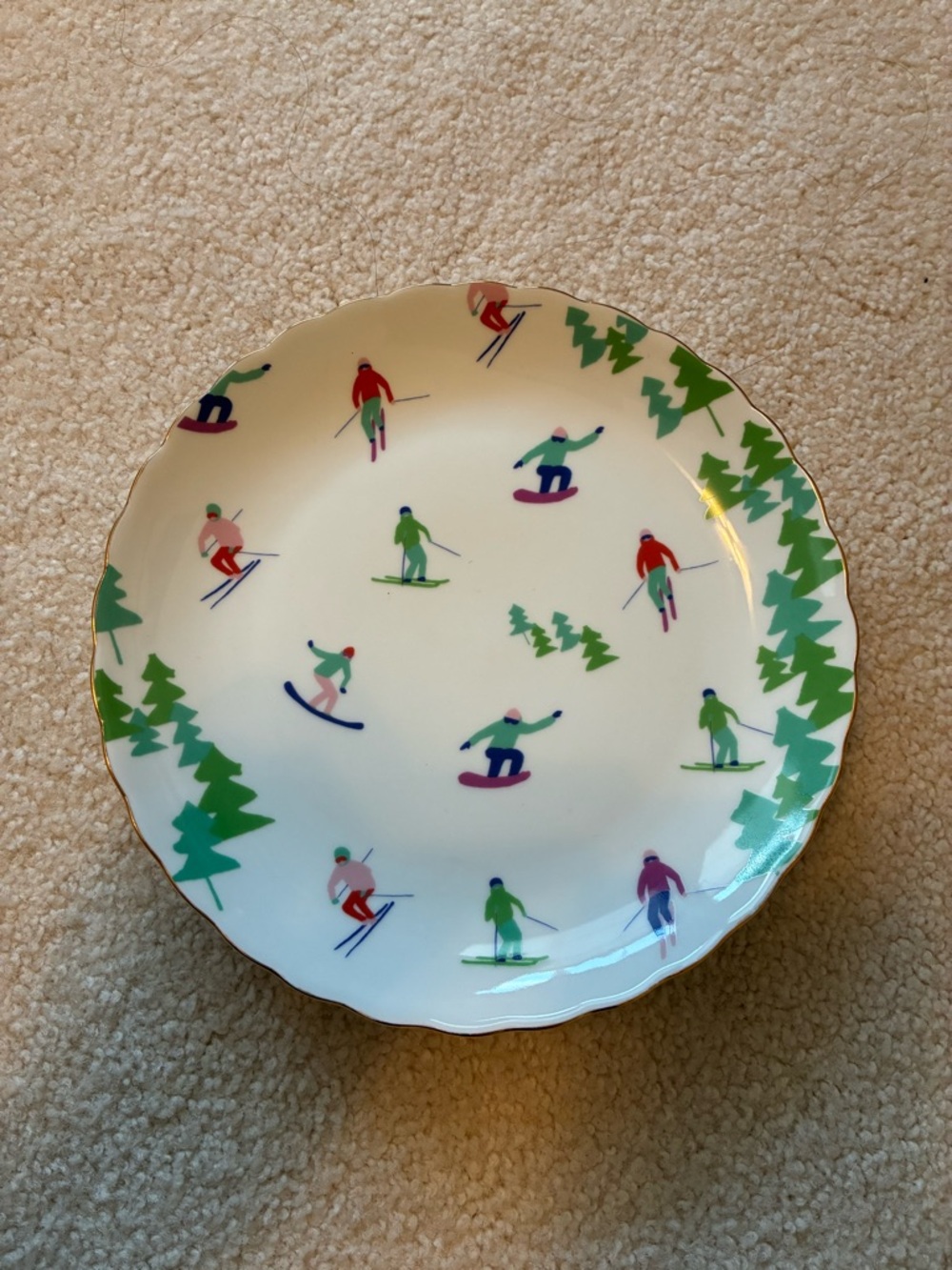White Dinner Plate with Multicolor Skiers and Green Tree Border